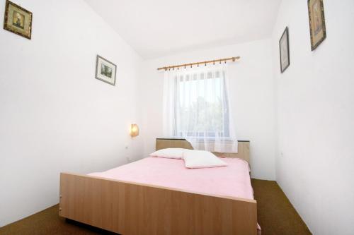 a bedroom with a bed with a pink blanket at Seaside apartments with a swimming pool Potocnica, Pag - 6407 in Borovići