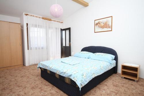 Schlafzimmer mit einem Bett mit blauer Decke in der Unterkunft Apartments with a parking space Pag - 6367 in Pag
