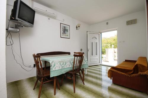 a dining room with a table and chairs and a television at Apartments with a parking space Pag - 6327 in Pag