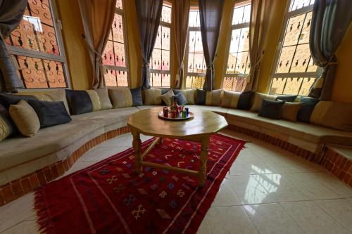 a living room with a couch and a table at Riad Parfums de OUARZAZATE in Ouarzazate