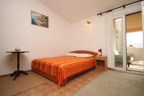 um quarto com uma cama com um cobertor laranja em Apartments with a parking space Pag - 6326 em Pag