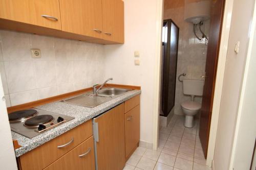 a small kitchen with a sink and a toilet at Apartments and rooms with parking space Vodice - 6260 in Vodice