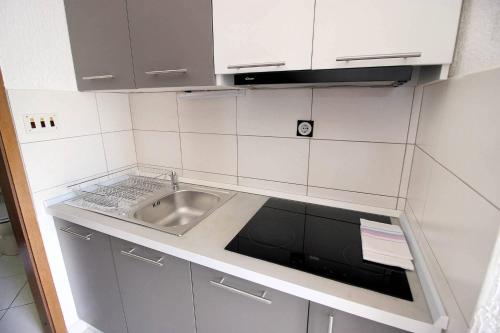 a kitchen with a sink and a counter top at Apartments by the sea Mandre, Pag - 6373 in Kolan