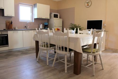 een keuken en eetkamer met een witte tafel en stoelen bij Apartments by the sea Sukosan, Zadar - 6402 in Sukošan