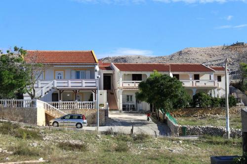 a house with a car parked in front of it at Apartments by the sea Kustici, Pag - 6320 in Kustići