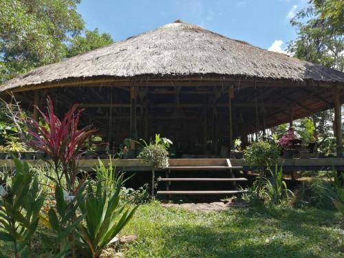 einen Pavillon mit einem Strohdach und einer Treppe im Garten in der Unterkunft Tad Lo - FANDEE ISLAND - Bolaven Loop Pakse in Ban Kiangtat