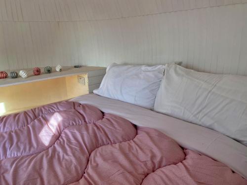 a unmade bed in a room with two pillows at Finest Retreats - Clotted Cream Cabin in East Looe