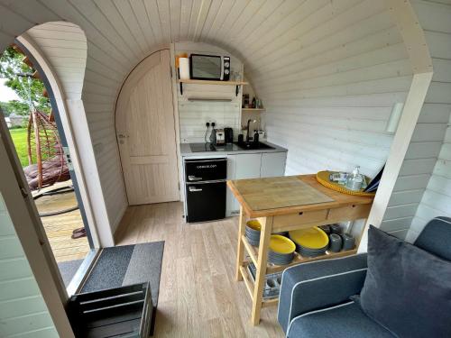 a small kitchen with a table in a tiny house at Finest Retreats - Jam First Cabin in East Looe