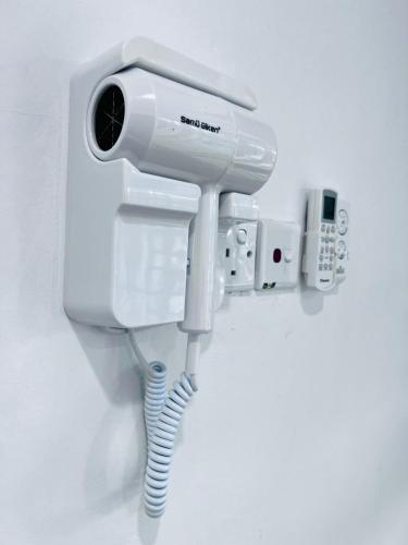 a white hair dryer is attached to a wall at SingBeach holiday house in Mersing