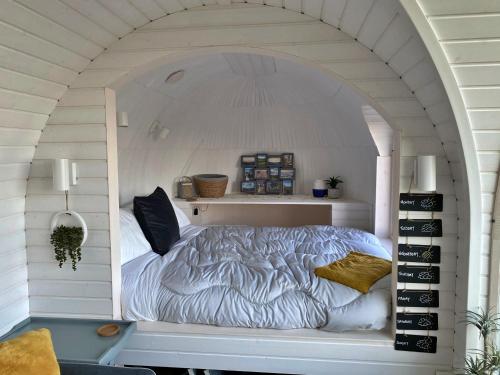 a bedroom with a bed in a white room at Finest Retreats - Jam First Cabin in East Looe
