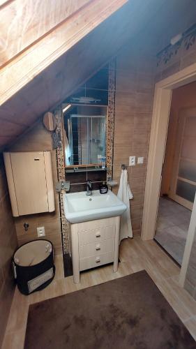 ein Bad mit einem Waschbecken und einem Spiegel in der Unterkunft Víkendový Dom U Vasila in Krahule