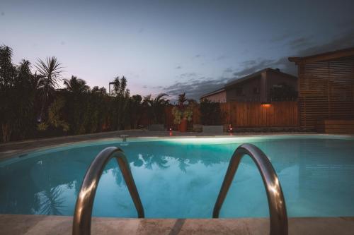 - une piscine avec une maison la nuit dans l'établissement Malaury, splendide villa avec piscine chauffée, à Saint-Gilles les Bains