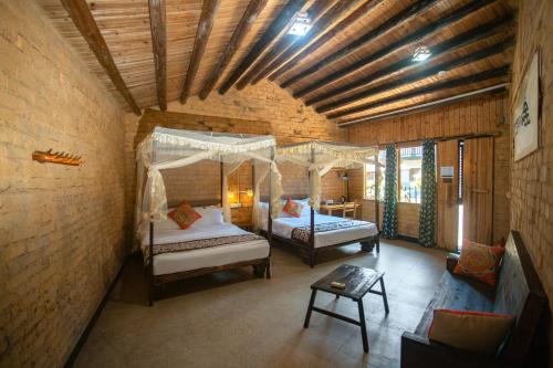 a bedroom with two beds in a brick wall at Yangshuo Loong Old House in Yangshuo