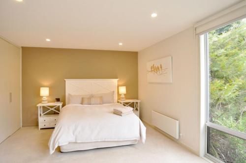 a bedroom with a bed and a large window at La mer in Inverloch