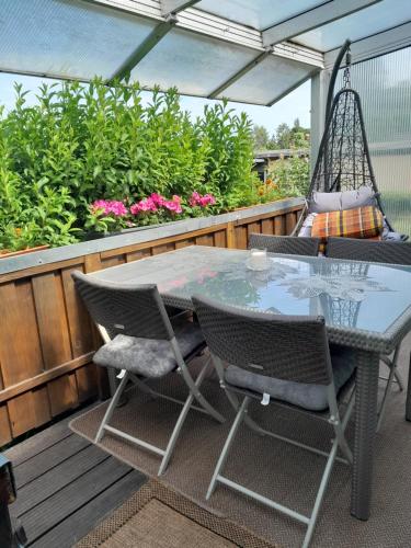 a table and chairs on a patio with a swing at Ferienhaus Alla, Neeberg/Usedom in Neeberg