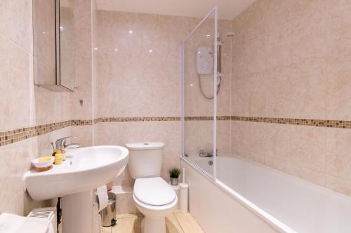 a bathroom with a toilet and a sink and a shower at Velvet 1-bedroom penthouse, Clockhouse, Hoddesdon in Hoddesdon