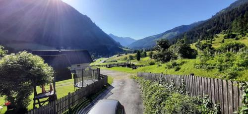 a road in a field with a fence and a mountain at Haus Fritz - Erholung in den Bergen in Donnersbachwald