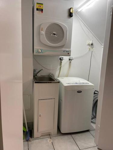 a small bathroom with a sink and a washing machine at Santana's Getaway in Agnes Water
