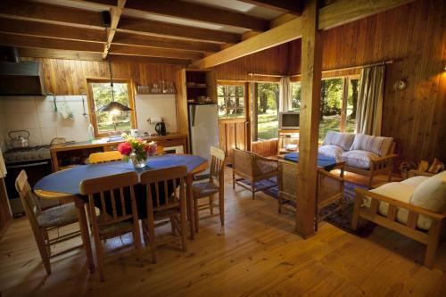 uma cozinha e sala de estar com mesa e cadeiras em Cabañas Metreñehue - Parque Metreñehue em Pucón