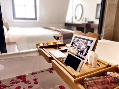 Cette chambre comprend un lit et une table avec un verre de vin. dans l'établissement Elysinam Boutique Hotel Ha Long, à Hạ Long