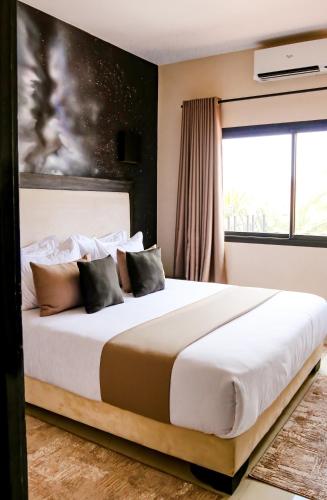 a bedroom with a large white bed with a window at Oscar Hotel by Atlas Studios in Ouarzazate