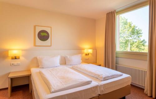 سرير أو أسرّة في غرفة في Dorint Hotel Durbach/Schwarzwald