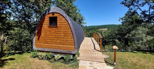 a small cabin with a wooden walkway in a yard at Green Paradise Glamping in Covas