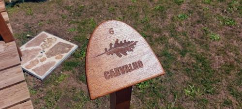 a wooden sign sitting on top of the grass at Green Paradise Glamping in Covas