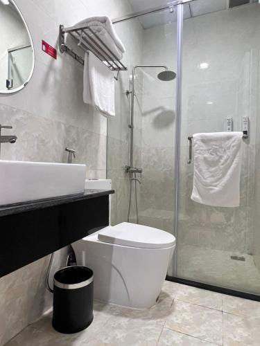 a bathroom with a sink and a toilet and a shower at Khách Sạn Hưng Nguyên Valley ĐàLạt in Da Lat