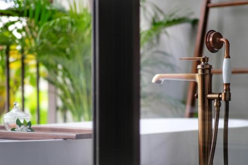 a bathroom with a brass faucet and a sink at Thai Fight Hotel in Lamai