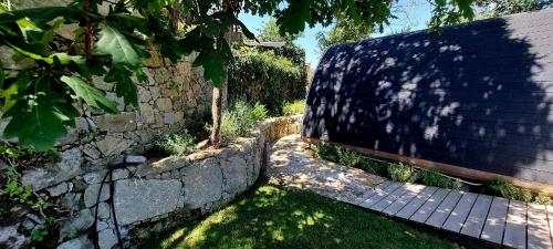 a stone wall next to a brick fence at Green Paradise Glamping in Covas