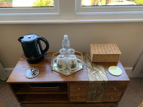 Una mesa de café con dos botellas de agua y una tetera. en San Brelade, en Paignton
