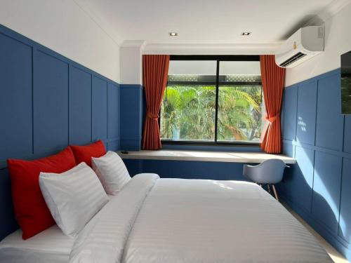 uma cama num quarto azul com uma janela em Penpark Place em Bangkok