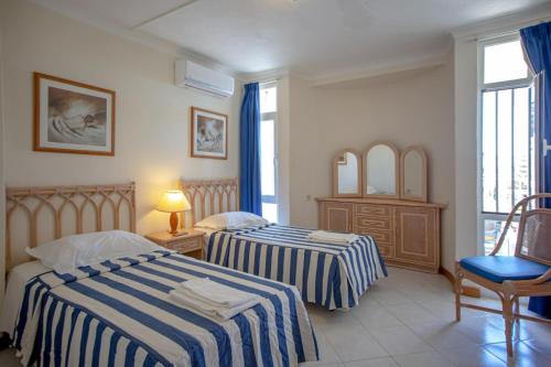 een hotelkamer met 2 bedden en een raam bij Praia da Oura Apartamento privado in Albufeira