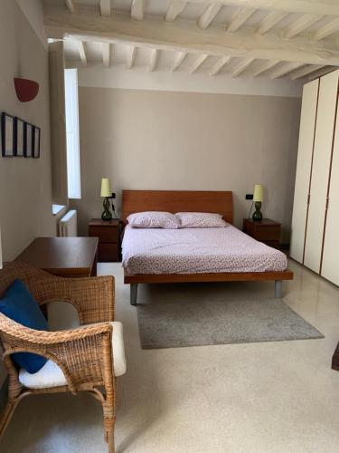 um quarto com uma cama e uma cadeira em Appartamento in centro storico a Lucca em Lucca