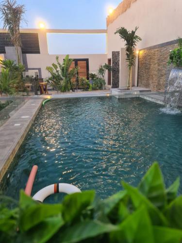 a swimming pool in a house with a fountain at Villa Bali Jeddah in Jeddah