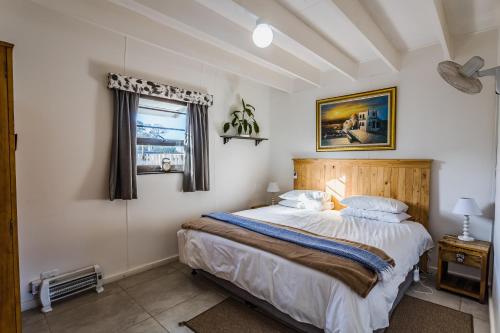 a bedroom with a large bed and a window at Arch Cabins Self Catering Homes Storms River in Stormsrivier