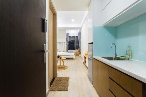 una cucina con pareti blu e lavandino e una camera di Oui! Oui! CBD Apartment - Rivergate Building ad Ho Chi Minh