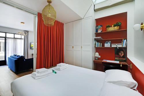 - une chambre avec un lit blanc et un rideau rouge dans l'établissement CMG - Magnifique appartement-Saint-Germain/Bon marché - Paris 7eme, à Paris