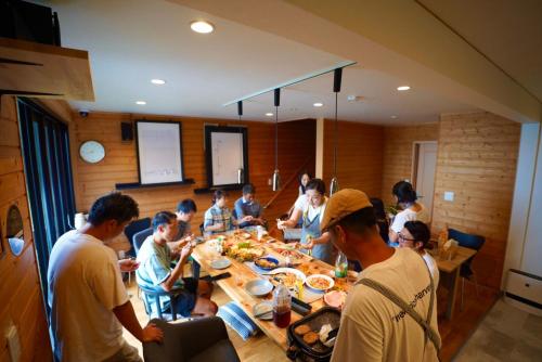 a group of people sitting around a table eating food at 佐世保VILLA青鹿Ur1 in Sasebo