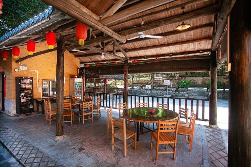 a restaurant with wooden tables and chairs and a balcony at Yangshuo Loong Old House in Yangshuo