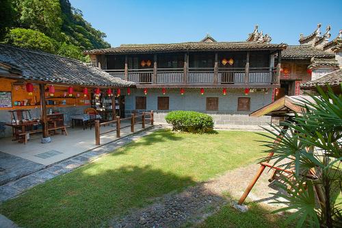 a large building with a balcony and a yard at Yangshuo Loong Old House in Yangshuo