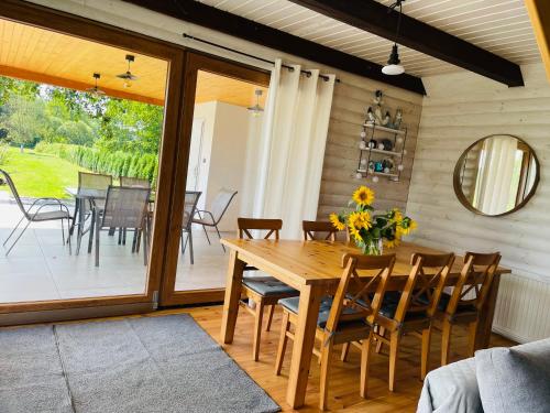 a dining room with a wooden table and chairs at Domek nad stawem RODOS in Raków