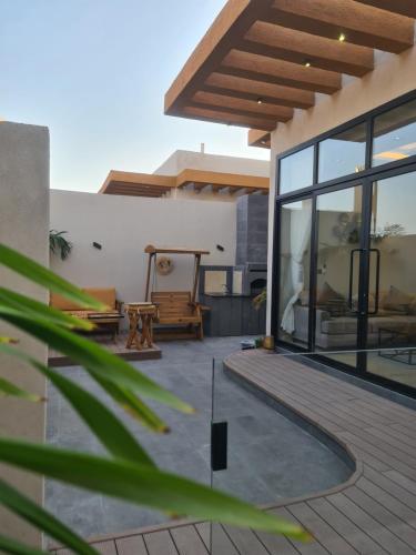 a patio with a wooden deck and a house at Villa Bali Jeddah in Jeddah