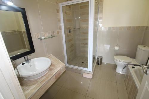 een badkamer met een wastafel, een douche en een toilet bij Saints View Resort Unit 8 in Uvongo Beach