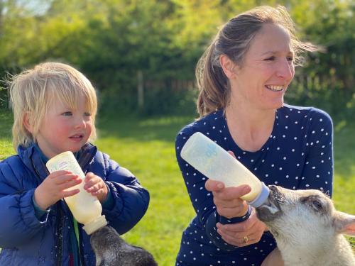 a woman and a little girl feeding a goat at The Chestnuts Holiday Cottages in Burgh le Marsh