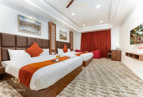 two beds in a hotel room with red curtains at KAREEM RESIDENCY in Srinagar