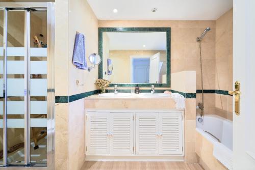 ein Bad mit einem Waschbecken und einem Spiegel in der Unterkunft Marbella SunCity in Marbella
