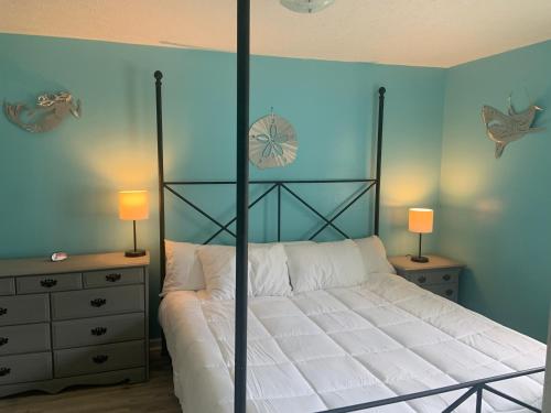 a bedroom with a large bed with white sheets at Cheerful two bedroom house 1.5 miles from beach. in Myrtle Beach