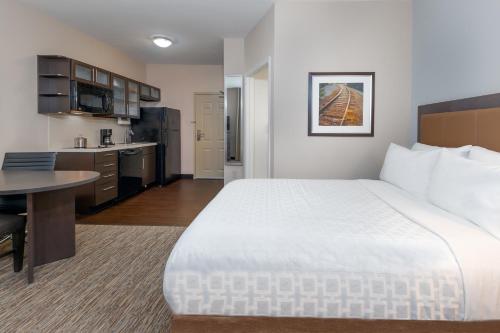 a hotel room with a large bed and a kitchen at Candlewood Suites Athens, an IHG Hotel in Athens